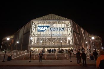 A group of people are standing in front of a building with the words SAP Center on it.